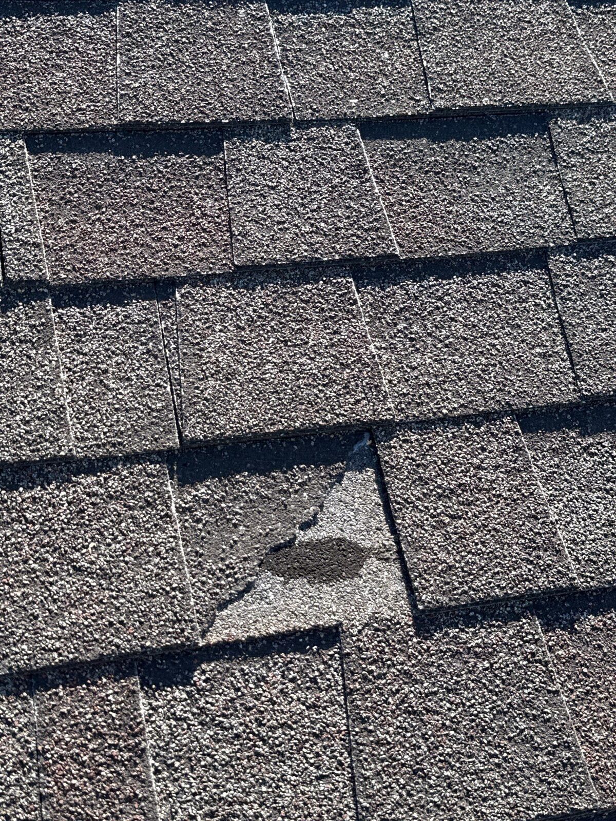 Granule loss and old patchwork on the failing roof