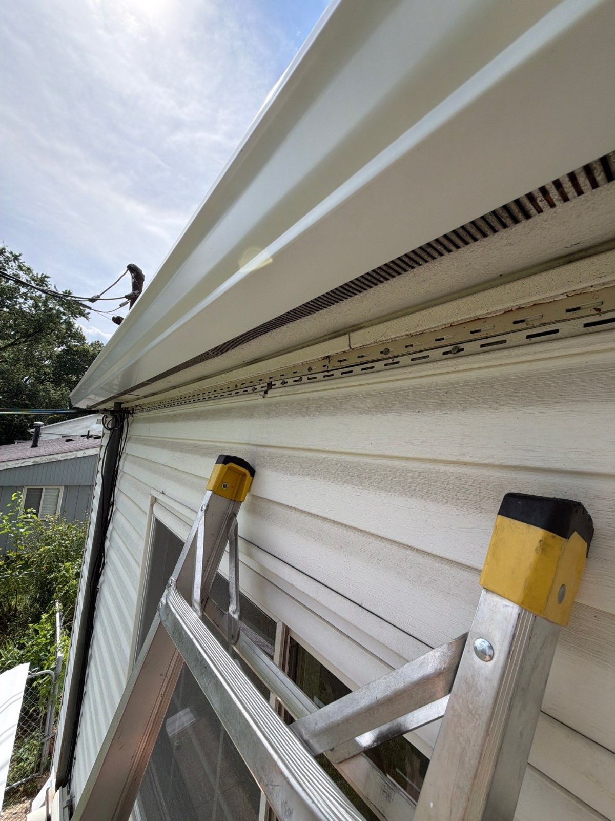 New white K-style gutter hung on the existing painted wood fascia